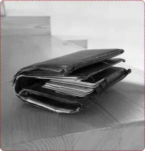 A bulky traditional leather wallet stuffed with cards and receipts